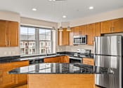 Thumbnail 26 of 59 - A modern kitchen with wooden cabinets and stainless steel appliances.