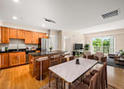 Thumbnail 3 of 59 - A modern kitchen with wooden cabinets and a dining table with chairs.