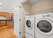 Thumbnail 43 of 59 - A white door is open to reveal a laundry room with a washer and dryer.