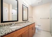 Thumbnail 42 of 59 - A bathroom with a marble counter top and a walk in shower.