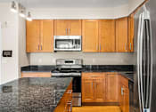 Thumbnail 39 of 59 - A kitchen with wooden cabinets and granite countertops.