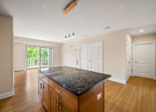 Thumbnail 41 of 59 - A kitchen with a black granite countertop and wooden cabinets.
