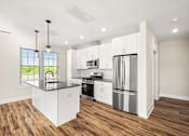 Thumbnail 19 of 39 - A modern kitchen with white cabinets and stainless steel appliances.
