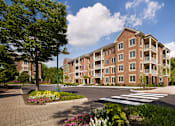 Thumbnail 34 of 39 - A large brick building with a green lawn in front.