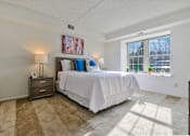 Thumbnail 13 of 30 - A bedroom with carpet flooring and a large window providing ample natural light.