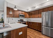 Thumbnail 19 of 30 - A modern kitchen with wooden cabinets and stainless steel appliances.