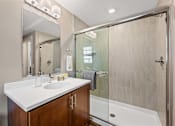Thumbnail 9 of 30 - A bathroom with a white countertop and a walk-in shower.