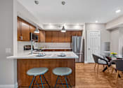 Thumbnail 17 of 30 - A kitchen with a bar stool and a dining table.
