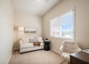 Thumbnail 8 of 45 - A living room with a white couch, a chair, and a lamp.