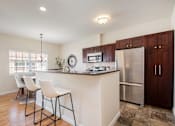 Thumbnail 2 of 45 - A kitchen with a bar area and a refrigerator.