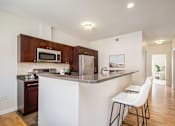 Thumbnail 13 of 45 - A kitchen with a white counter and brown cabinets.