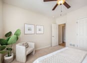 Thumbnail 41 of 45 - A living room with a white couch, a potted plant, and a ceiling fan.