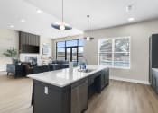 Thumbnail 8 of 28 - an open kitchen and living room with a large white counter top at The Junction at Rogers, Rogers, Arkansas