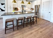 Thumbnail 5 of 28 - A kitchen with white cabinets and a black countertop.