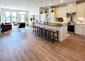 Thumbnail 1 of 28 - A kitchen with a bar area and a dining table.