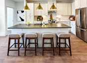 Thumbnail 3 of 28 - A kitchen with a bar and stools.
