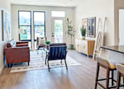 Thumbnail 17 of 28 - A living room with a brown chair and a blue chair in the middle of the room.