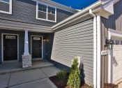 Thumbnail 3 of 33 - the front of a blue house with a driveway and a garage door at The Prairie Villas, Dardenne Prairie, MO