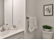 Thumbnail 4 of 33 - a bathroom with a toilet and a sink and a mirror at The Prairie Villas, Dardenne Prairie, Missouri
