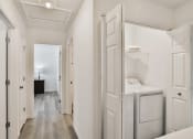 Thumbnail 11 of 33 - a washer and dryer in a white laundry room with white walls and wood at The Prairie Villas, Dardenne Prairie