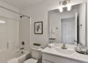 Thumbnail 13 of 33 - a bathroom with a large mirror and a sink and a toilet at The Prairie Villas, Dardenne Prairie, MO 63368