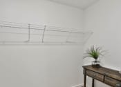 Thumbnail 19 of 33 - a white room with a wooden table and a shelf with a plant at The Prairie Villas, Missouri