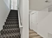Thumbnail 20 of 33 - a staircase in a home with black and white stairs and a white door at The Prairie Villas, Dardenne Prairie, 63368