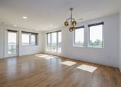 Thumbnail 2 of 32 - an empty living room with hardwood floors and a chandelier  at 2200 LaSalle, St Louis, Missouri
