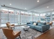 Thumbnail 20 of 32 - a living room with a couch and chairs and large windows at 2200 LaSalle Apartments, St Louis, MO