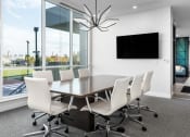 Thumbnail 15 of 32 - a conference room with a large window and a table with white chairs at 2200 LaSalle Apartments, St Louis, 63104