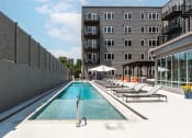 Thumbnail 9 of 32 - a swimming pool with lounge chairs next to a building at 2200 LaSalle Apartments, Missouri, 63104