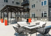 Thumbnail 12 of 32 - an outdoor patio with chairs and tables and a grill at 2200 LaSalle Apartments, Missouri
