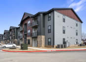 Thumbnail 15 of 28 - an apartment building with a car parked in front of it at The Junction at Rogers, Rogers, 72756