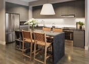 Thumbnail 54 of 58 - a kitchen with a large island and a table with chairs at Bemiston Place Apartments, Clayton, MO