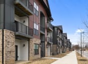 Thumbnail 14 of 28 - a row of town houses with balconies and a sidewalk at The Junction at Rogers, Rogers, Arkansas
