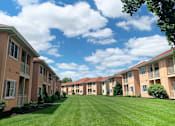 Thumbnail 26 of 45 - A row of apartment buildings with green lawns in front.