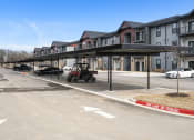 Thumbnail 28 of 28 - an empty parking lot in front of a row of apartment buildings at The Junction at Rogers, Rogers, AR