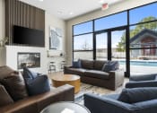 Thumbnail 6 of 28 - a living room with couches and a fireplace and a pool at The Junction at Rogers, Rogers