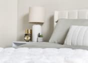 Thumbnail 25 of 28 - a white bed with white bedding and a white nightstand with a white lamp at The Junction at Rogers, Rogers, Arkansas