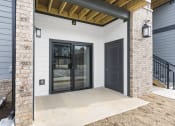Thumbnail 22 of 28 - the front porch of a home with a black door at The Junction at Rogers, Rogers