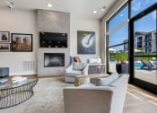 Thumbnail 28 of 33 - modern clubroom with floor to ceiling windows, fireplace, large tv and conversational seating at The Prairie Villas, Dardenne Prairie, MO