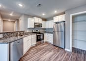 Thumbnail 1 of 32 - A kitchen with white cabinets and stainless steel appliances.