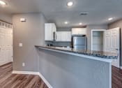 Thumbnail 5 of 32 - A kitchen with white cabinets and a granite countertop.