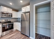 Thumbnail 6 of 32 - A modern kitchen with a stainless steel refrigerator and oven.