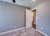 Thumbnail 9 of 32 - A room with a white door and carpeted floor.