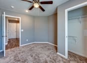 Thumbnail 10 of 32 - A room with a ceiling fan and a carpeted floor.