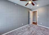 Thumbnail 12 of 32 - A room with a ceiling fan and a door.