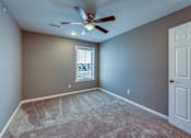 Thumbnail 16 of 32 - A room with a ceiling fan and a window.