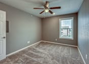 Thumbnail 30 of 32 - A room with a ceiling fan and a window with blinds.