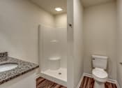 Thumbnail 31 of 32 - A white toilet is in a small bathroom with a walk-in shower.